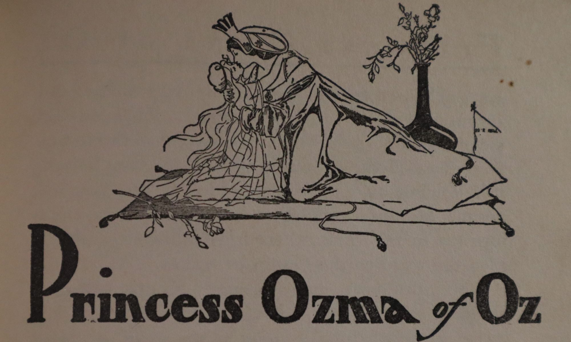 Glinda of Oz kissing Princess Ozma over the text "Princess Ozma of Oz"